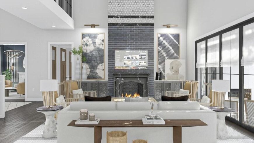 Great room with a light gray sofa, cushioned wingback chairs, and marble fireplace topped with a TV.