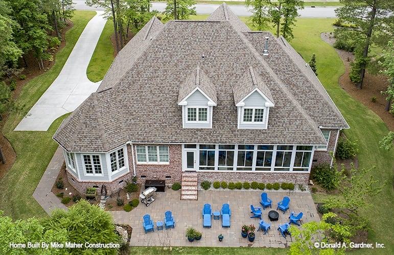 Aerial view of the house showing the hipped rooflines, gable dormers, and expansive outdoor living.