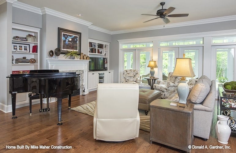 The great room includes a baby grand piano and french doors leading to the rear porch.