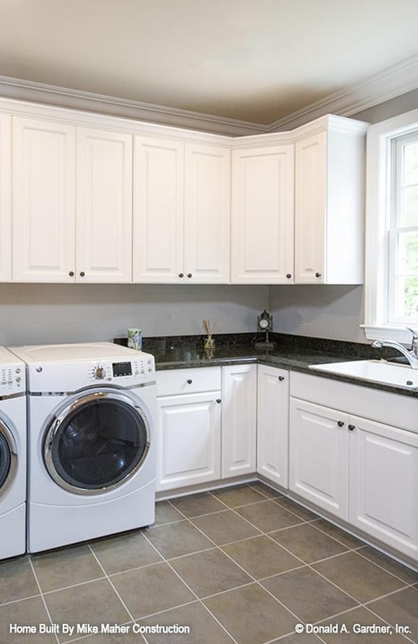 Mudroom with storage cabinets, a built-in bench, a round pendant light, and easy access to the powder room.