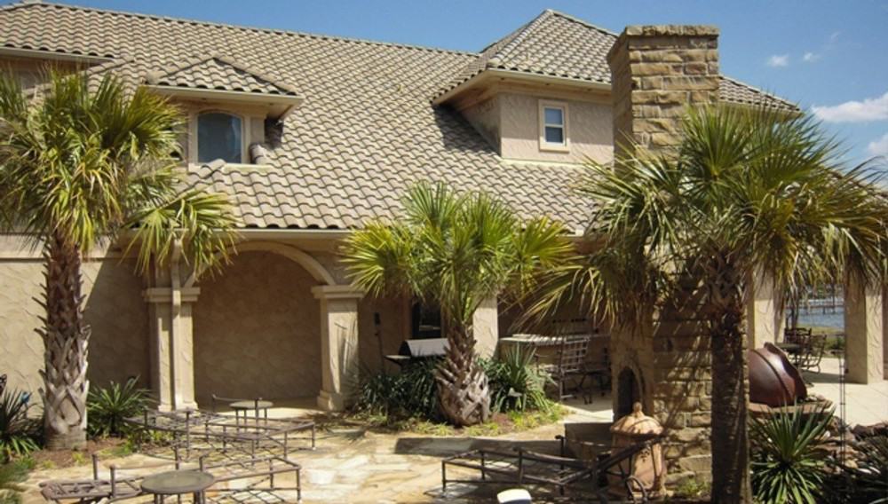 Airy patio with a brick fireplace and metal seats over flagstone flooring.