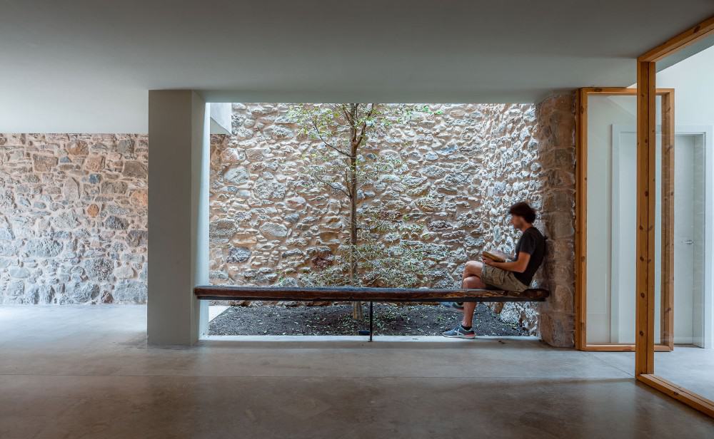 Hallway with white ceiling and rocks on the wall.