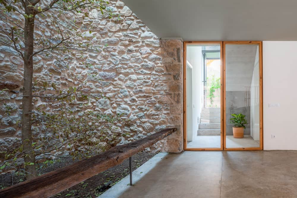 A bleachers seat made on acacia tree with sliding door and plants.