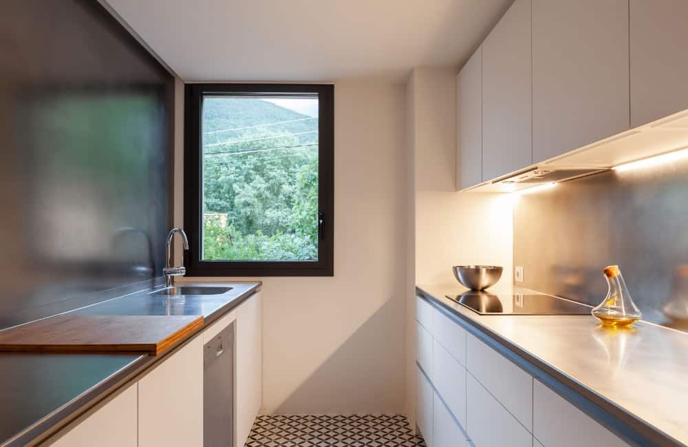 A kitchen made on metals and woods with black accent window.