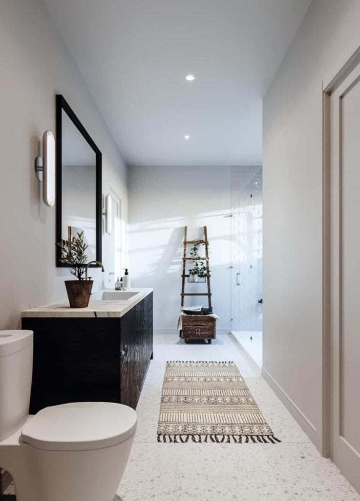 The primary bathroom offers a marble top vanity, a toilet, and a walk-in shower.