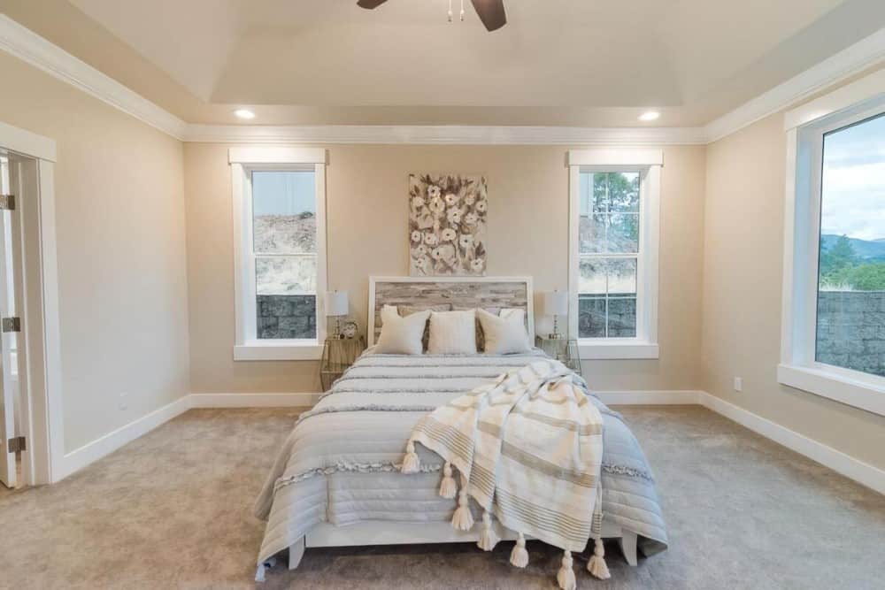 White framed windows bring natural light into the primary bedroom.