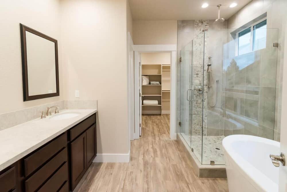 The primary bathroom is equipped with a dual sink vanity, a freestanding tub, a shower area, and a walk-in closet.