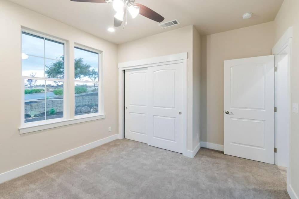 A large white framed window brings natural light into the bedroom.