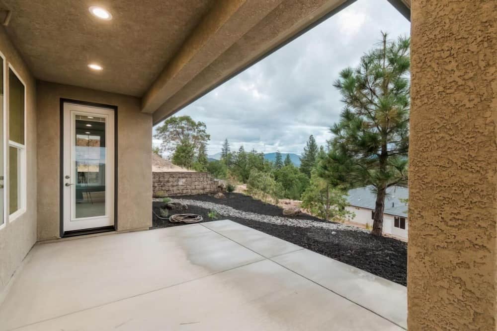 Covered porch with textured walls and concrete flooring.