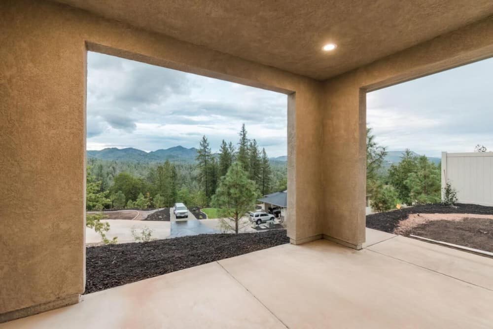 The covered porch includes an expansive view of the surrounding landscape.