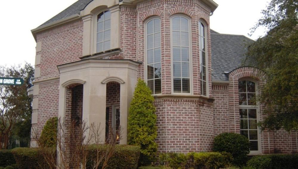 A closer look at the home entry with covered portico framed with narrow arches.