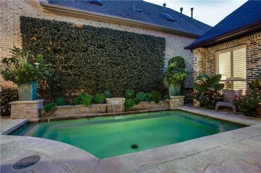 A living wall with a water feature serves as a nice backdrop to the swimming pool.