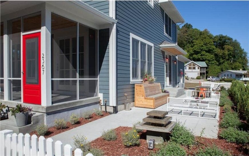 Right exterior view with a concrete patio filled with wooden and metal benches along with an outdoor dining set.Right exterior view with a concrete patio filled with wooden and metal benches along with an outdoor dining set.