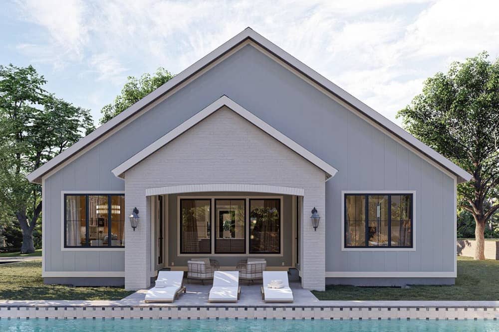 Rear exterior view with a covered porch and a swimming pool complemented with white loungers.
