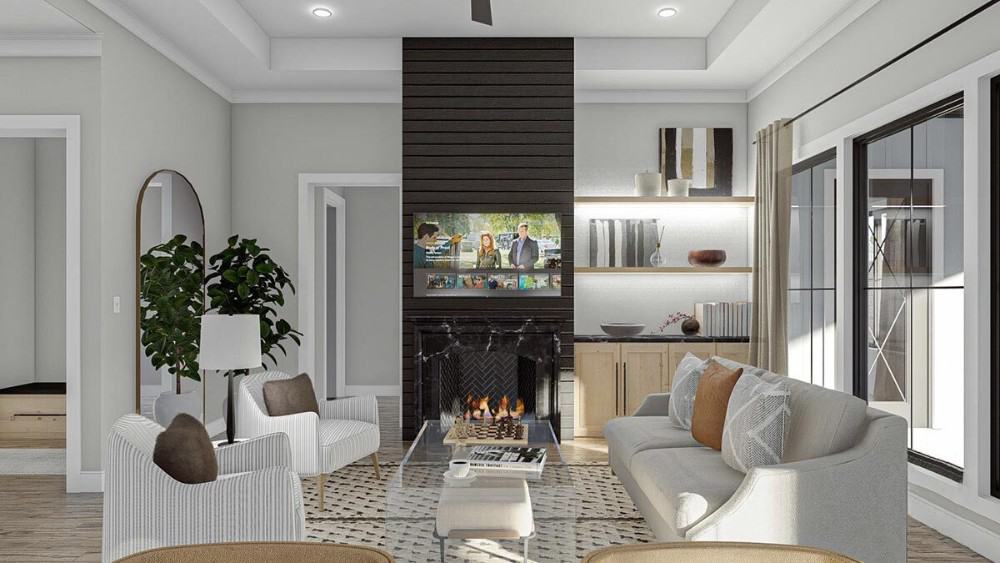 The great room has a tray ceiling, gray seats, and a fireplace topped with a TV.