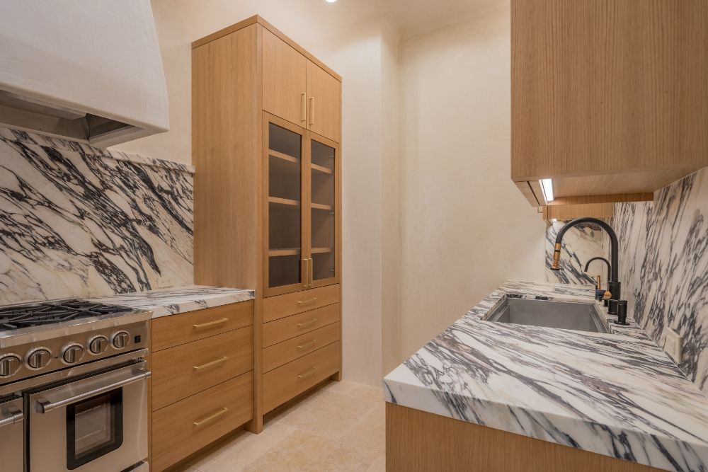 Main kitchen features marble counter, custom-built-steel-and-glass cabinetry and Sub-Zero appliances.