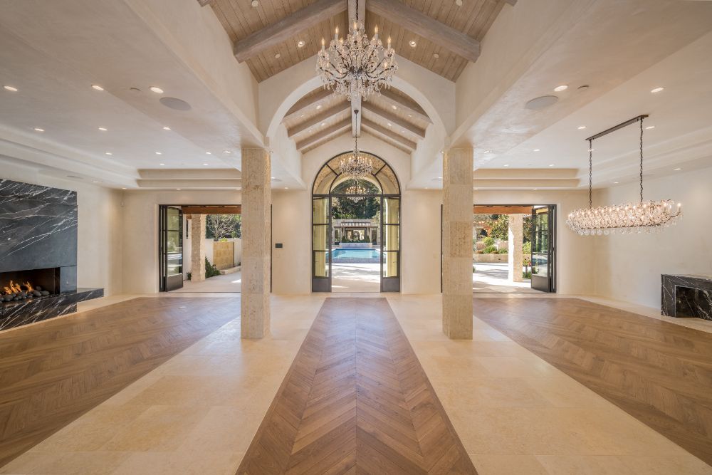 Spacious conference center with a cathedral-beamed ceiling with crystal chandelier and two-sided fireplace.