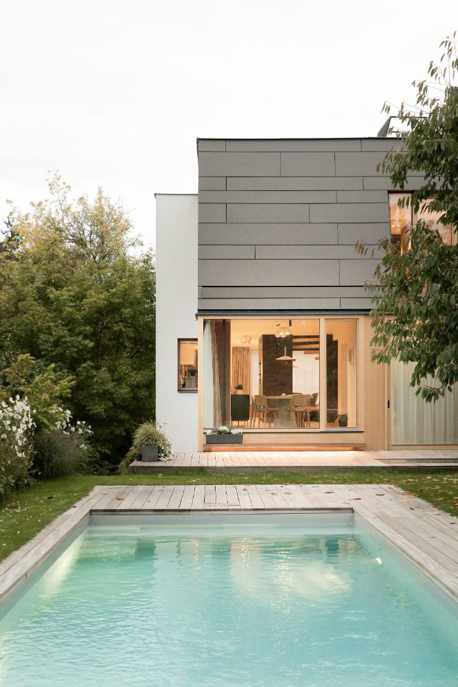 Cherry tree house with large swimming pool in front.