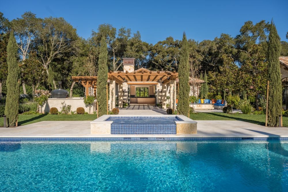 Swimming pool area with landscape garden, lush greenery beside the outdoor lounges.