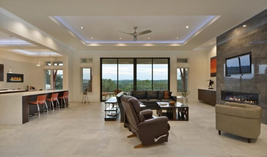 An open layout view of the kitchen and great room crowned with tray ceilings.