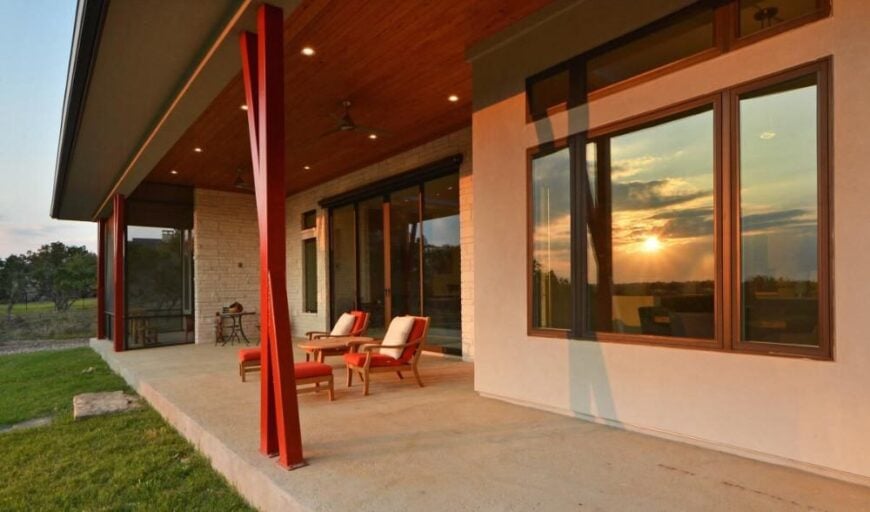 Outdoor living with cushioned lounge chairs matching with the red pillars.