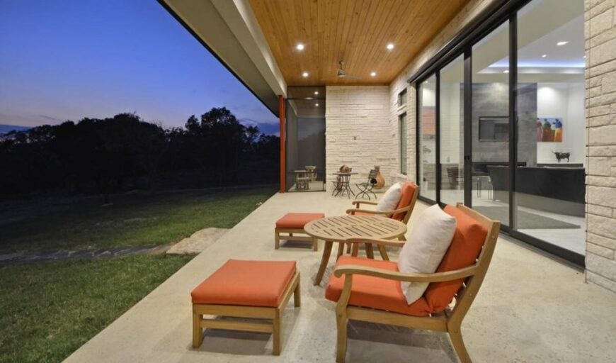 Night view of the outdoor living brightened by recessed lights that are mounted on the wood-paneled ceiling.