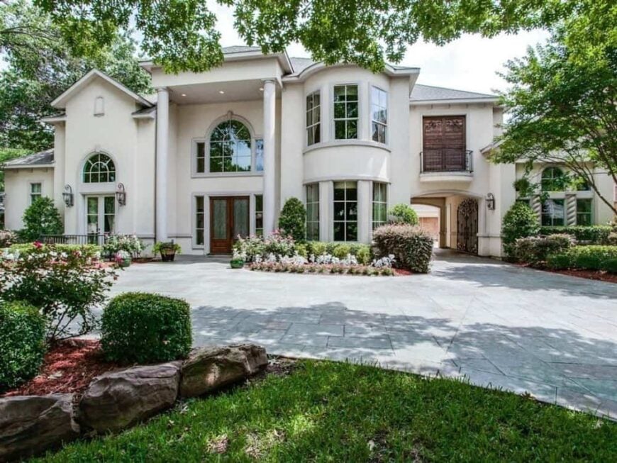 Front exterior view showcasing its two-story entry and an arched portico that connects the garage to the house.