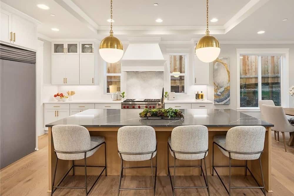 A tray ceiling mounted with glass globe pendants crowns the kitchen.