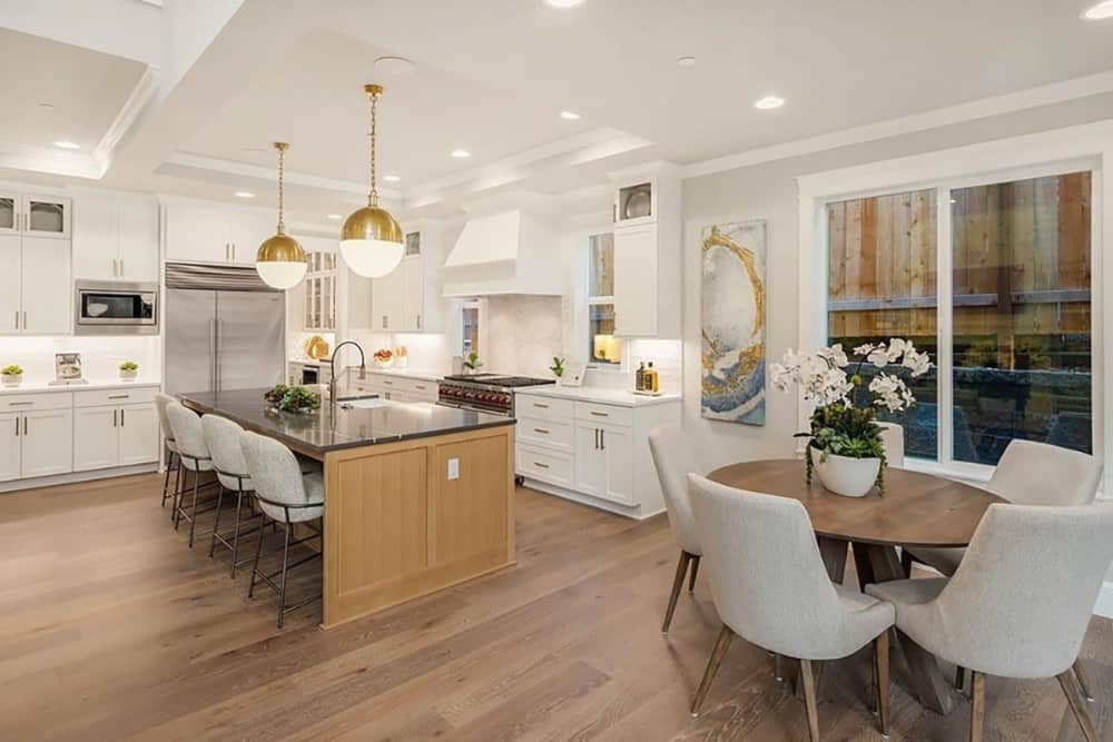 The breakfast nook furnished with a round dining set adjoins the kitchen.