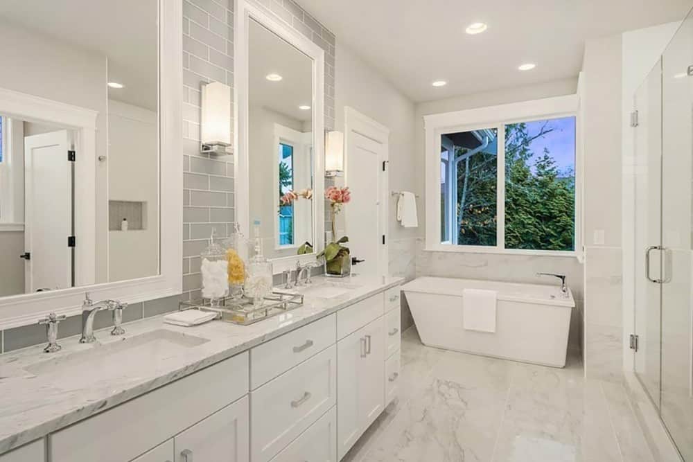 The primary bathroom includes a dual sink vanity with white framed mirrors and linear sconces.