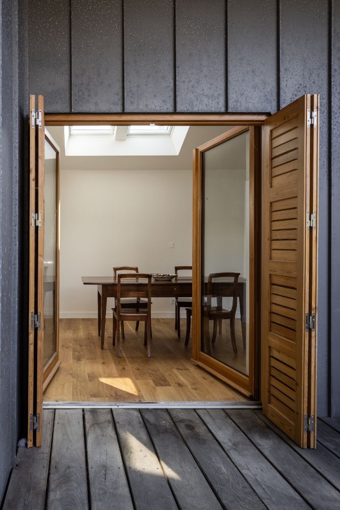 Entrance to the dining area with wooden folding and glass doors.