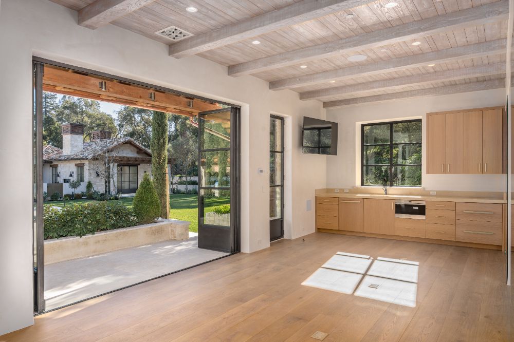 Conference center with cathedral-beamed ceiling, kitchen sink and custom-built-wooden cabinetry.