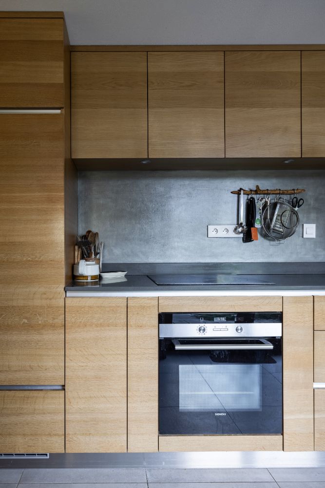 Kitchen area with steel sink, wooden cabinets, nd built-in appliances.