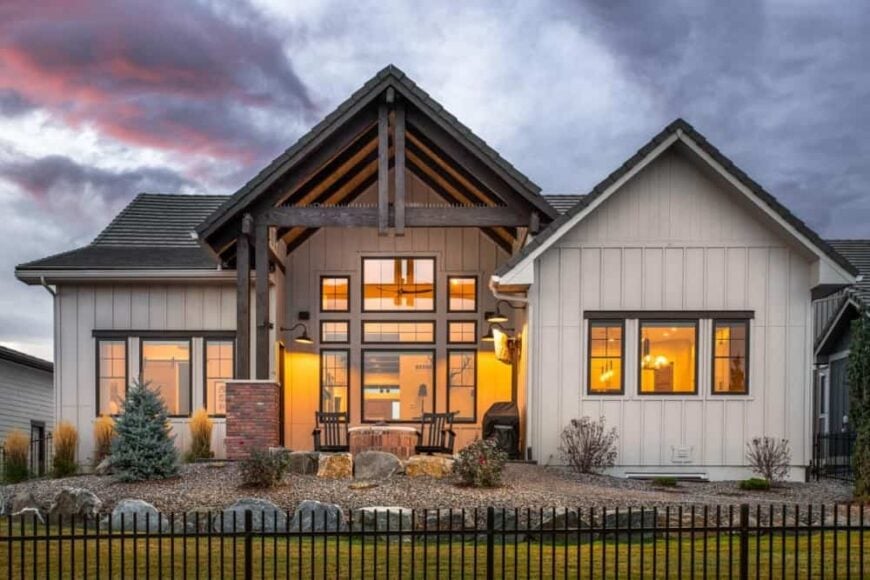 Rear exterior view showcasing its board and batten siding, gable roofs, and a covered porch accentuated with rustic wood trims.