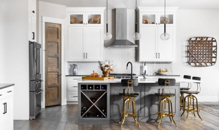 The kitchen has white cabinetry, slate appliances, and a breakfast island fitted with a built-in wine rack.