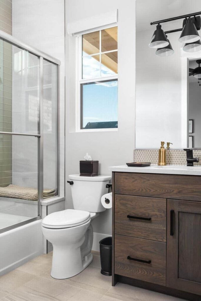 This bedroom is equipped with a wooden vanity, a toilet, and a walk-in shower with a tiled bench.