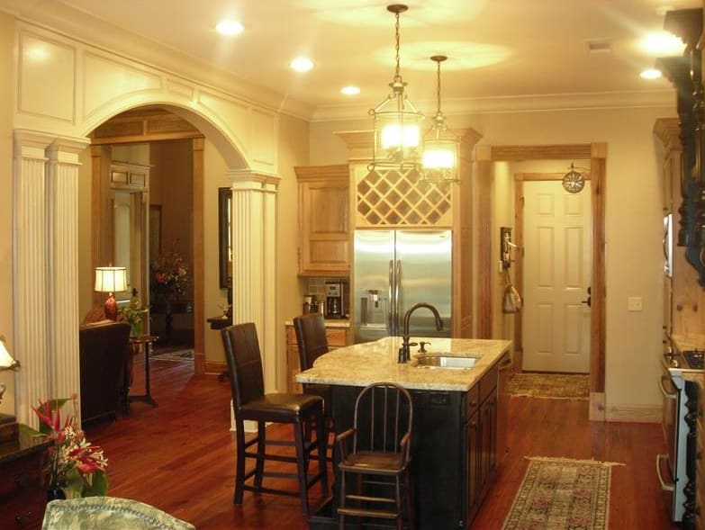 The kitchen is equipped with stainless steel appliances, a built-in wine rack, and a breakfast island fitted with a sink.