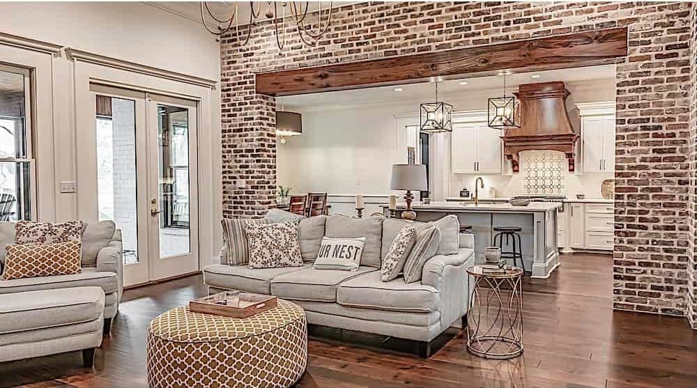 The great room opens into the kitchen highlighted by red bricks and wooden timber.