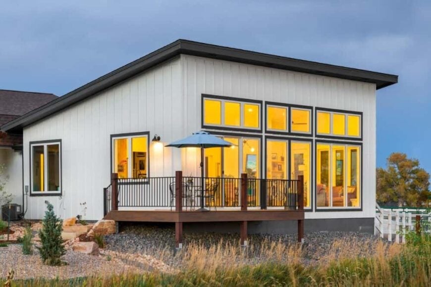Side exterior view showcasing its slanted rooflines, massive windows, and spacious deck.
