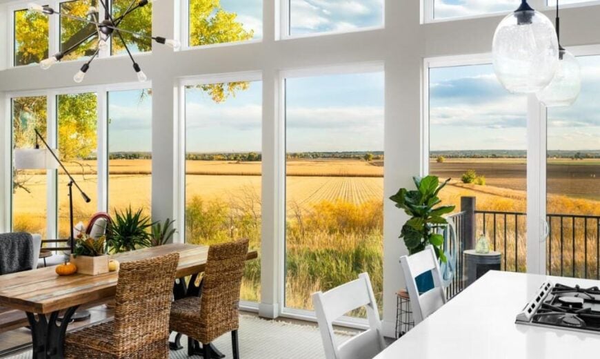 A wall of windows in the open living space overlooks the expansive field.