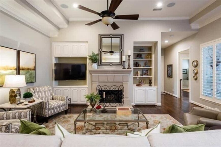Family room with mismatched seats, a glass-top coffee table, and a fireplace flanked by built-in cabinets.