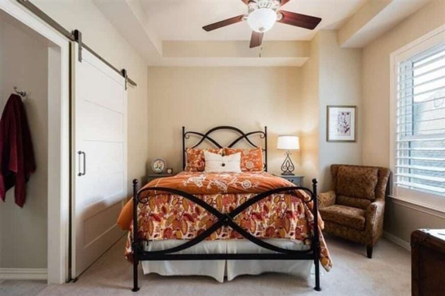 Another bedroom with carpeted floor, beige walls, and a private bath enclosed in a sliding barn door.