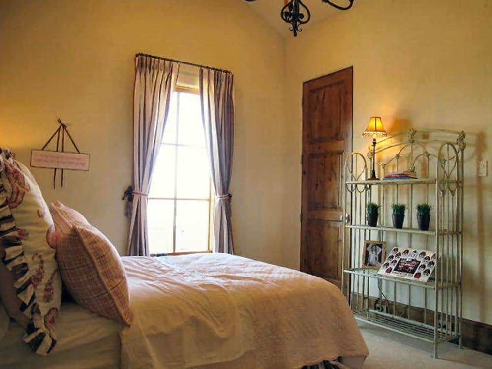 Another bedroom with a vaulted ceiling, carpeted floor, and a large window inviting natural light in.
