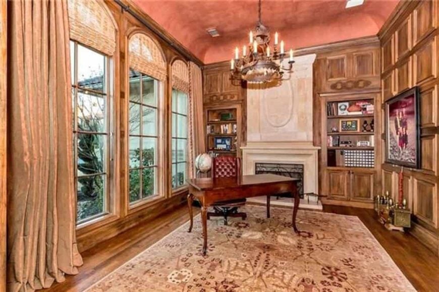 Study with a coved ceiling, a marble fireplace, and a hardwood floor that extends to the wood-paneled walls.