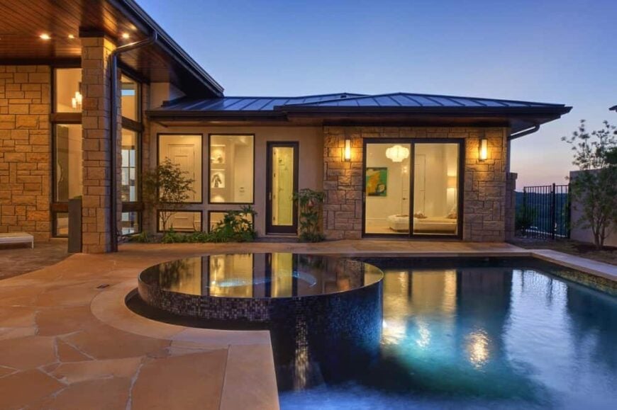 Ambient lighting from the outdoor sconces and recessed lights bring a romantic vibe to the pool terrace.