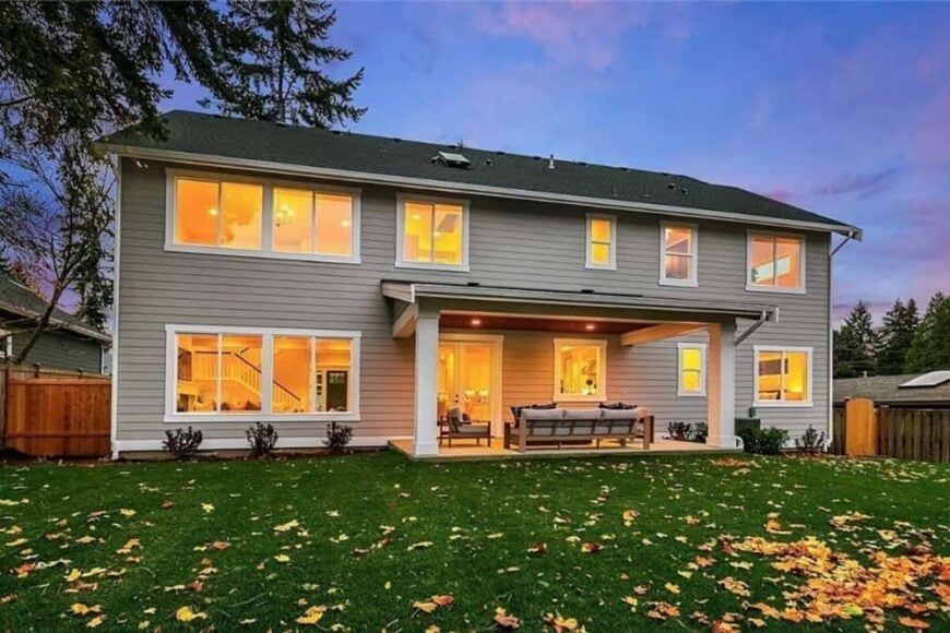 Rear exterior view showcasing its horizontal lap siding, a covered porch, and plenty of windows.