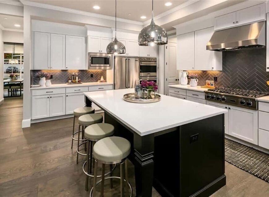 A couple of chrome pendants along with round bar stools complement the kitchen island.