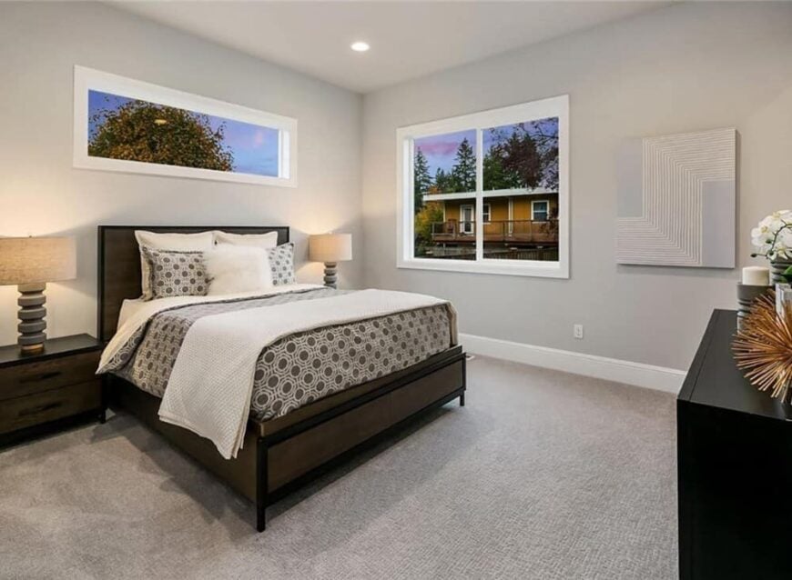 Another bedroom with carpeted floor and gray walls adorned with geometric artwork.