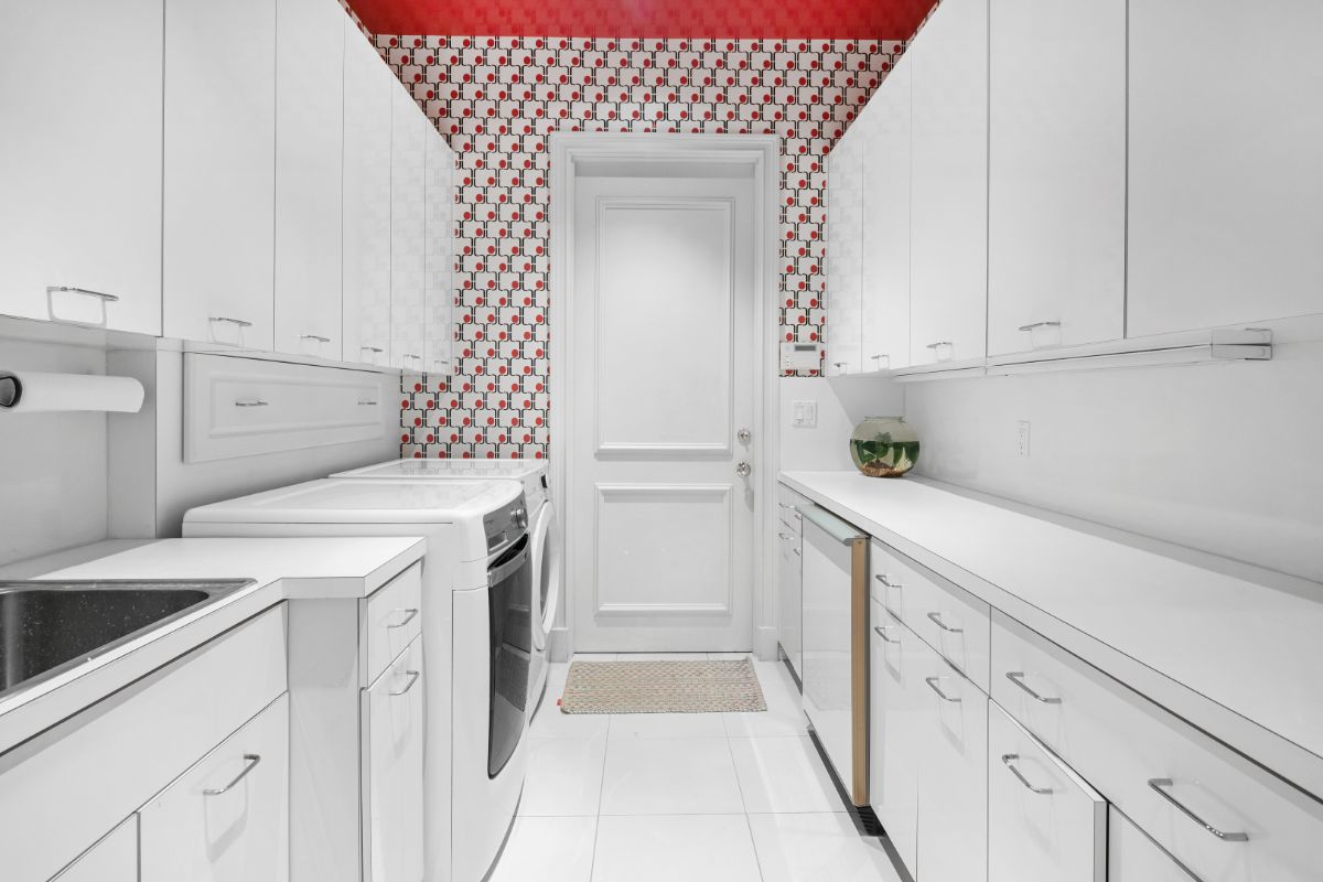 Laundry area with built in appliances and cabinets.