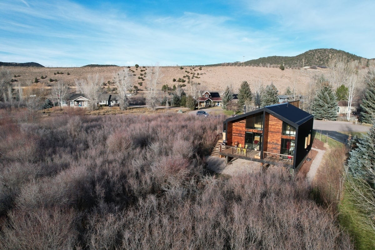 An aerial view of the house during summer surrounded with bird sanctuary.